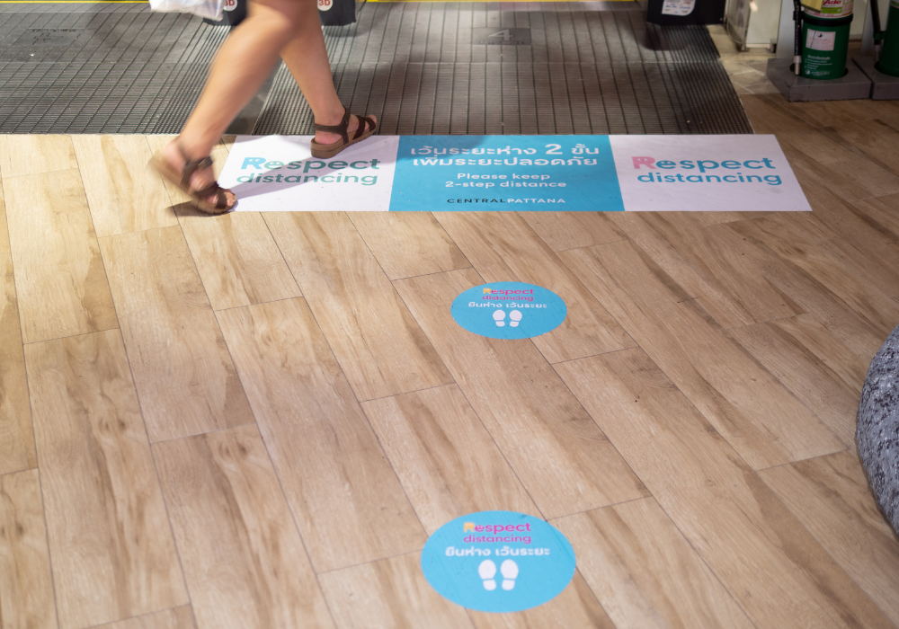 the best sticker printing Brisbane - image of social distancing floor stickers on tiled floor at shopping centre - call Infinite Print today